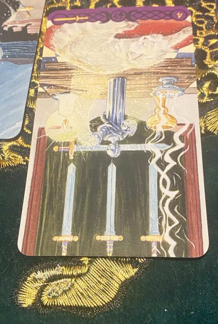 Four of Swords (Reversed) from Tarot of Pagan Cats. A white cat sleeps on a red cushion