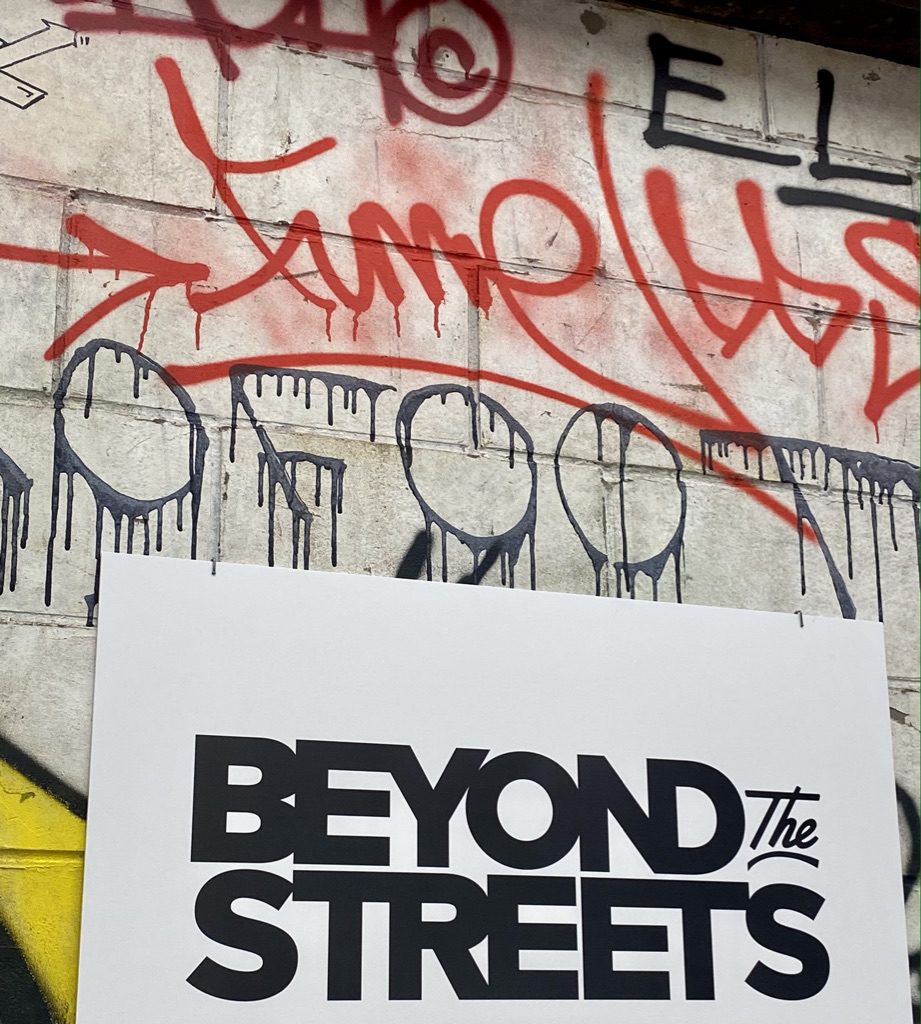 Fume tag in red [aint dominates BEYOND The STREETS black on white sign