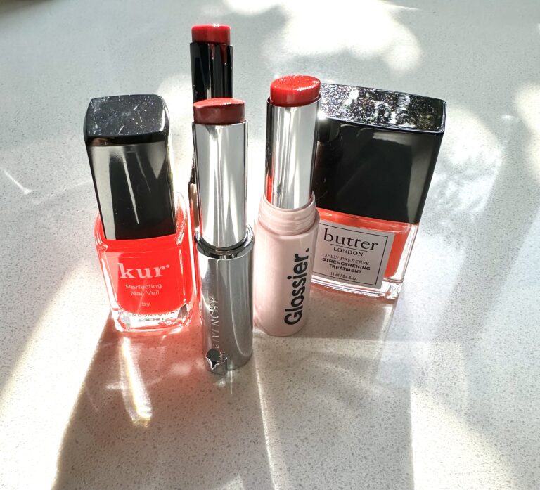three sheer red lipsticks and two sheer red nail polishes photographed in LA sun