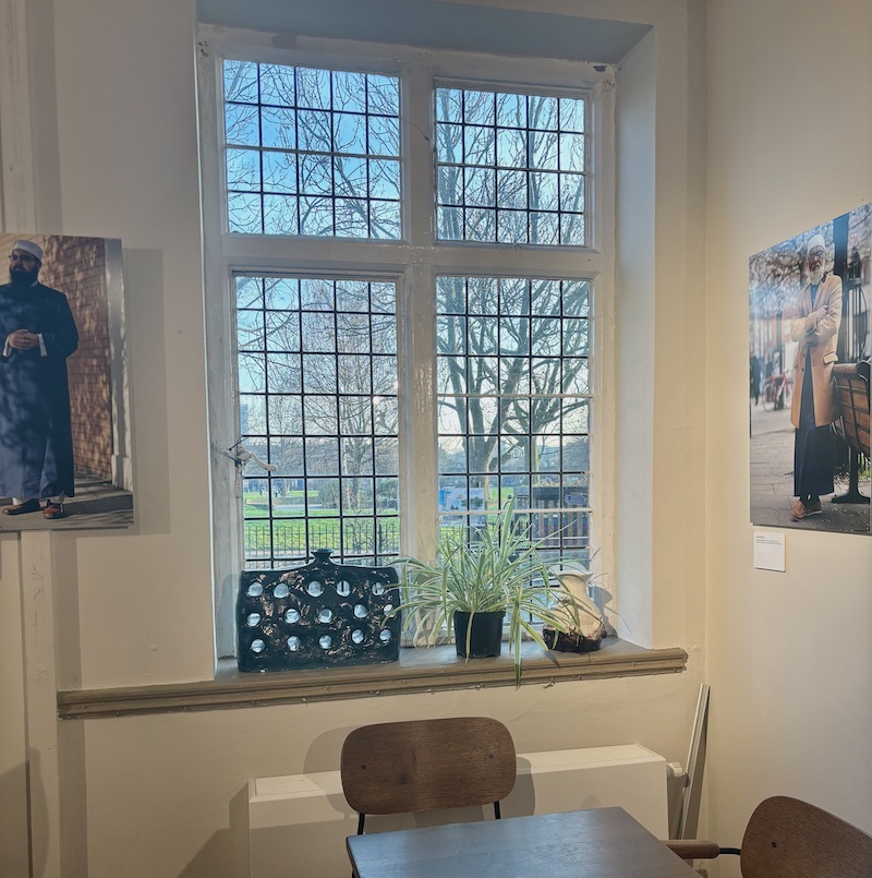 Window at Oxford House Cafe, on each side of it photographs by Rehan Jamil part of the exhibition Jummah Aesthetics: British Muslim Men and Their Sartorial Choices curated by Dr Fatima Rajina