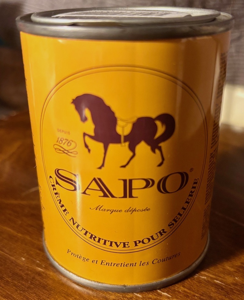 Can of SAPO saddle oil on a piece of wood, golden-yellow and brown and beautiful